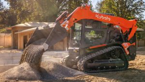 Kubota SVL75-3 Skid Steer Loader on a residential job site clearing dirt.