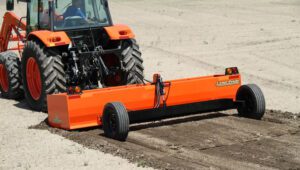 Person in a Kubota tractor with a Land Pride BB45 Series Drag Scraper.