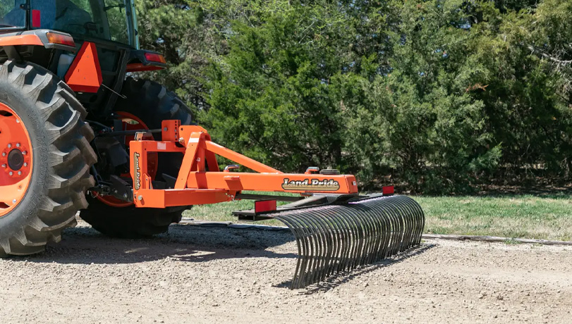 Land Pride LR37 Series Landscape Rake attached to the back of a Kubota tractor working a field.