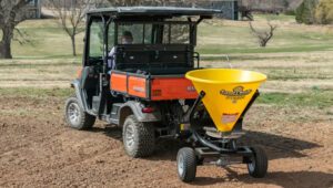 New Land Pride PTS Series Spreader attached to Kubota RTV seeding a plot of land.
