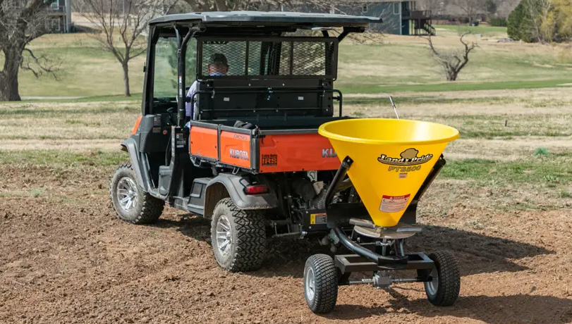 New Land Pride PTS Series Spreader attached to Kubota RTV seeding a plot of land.