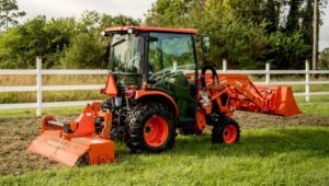 Land Pride RTA12 Series Rotary Tiller attached to the back of a Kubota tractor tilling a field.