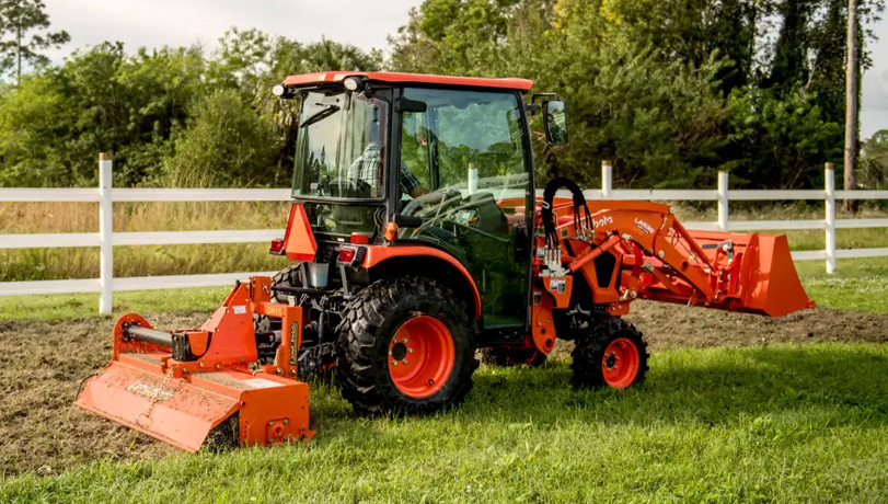 Land Pride RTA12 Series Rotary Tiller attached to the back of a Kubota tractor tilling a field.
