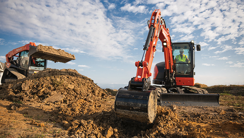 New Kubota KX057-5 Excavator on a heavy duty construction site clearing land and soil.