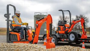 Worker in a Kubota K008-5 Excavator moving gravel around a job site.