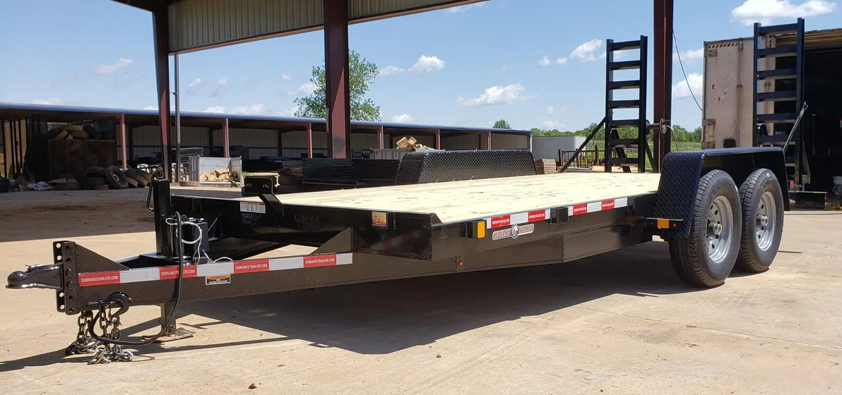 Currahee Flatbed Trailer parked on a jobsite underneath an awning.
