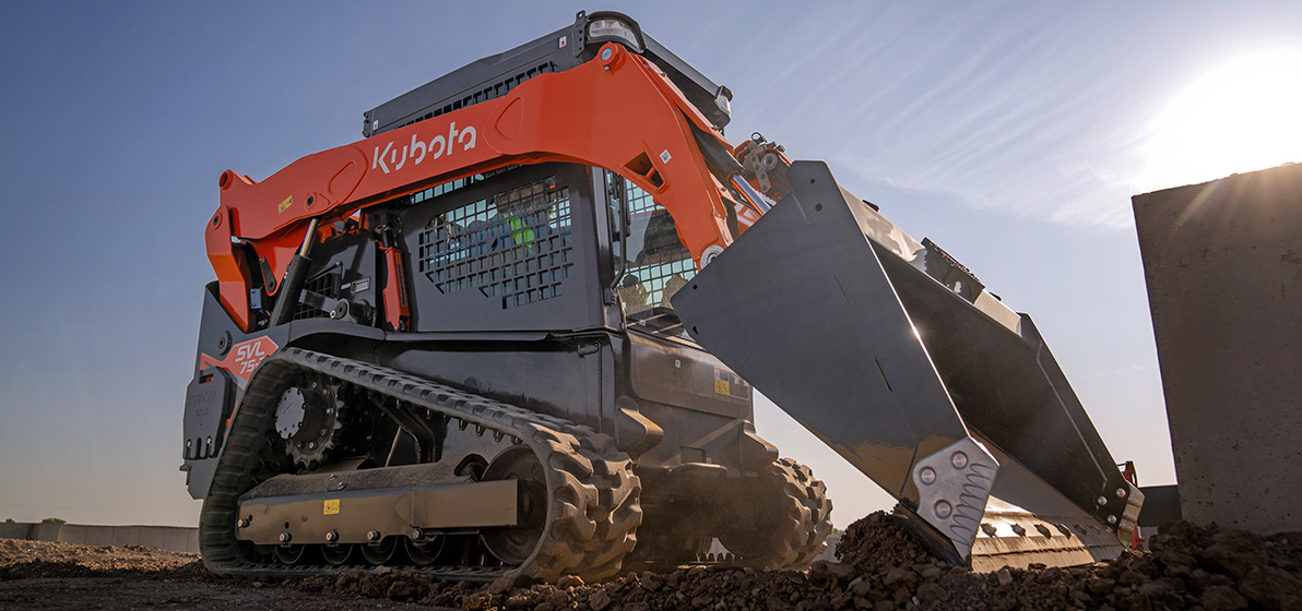 Kubota SVL753 Skid Steer on a bright, sunny day clearing a job site for construction work.
