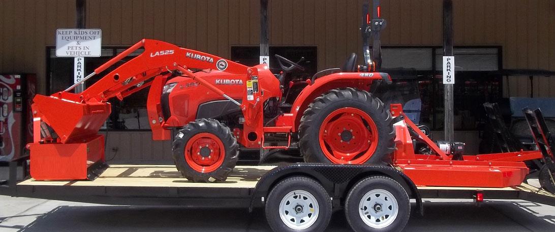Kubota tractor package with a tractor and various attachment in front of the Steen Enterprises shop.