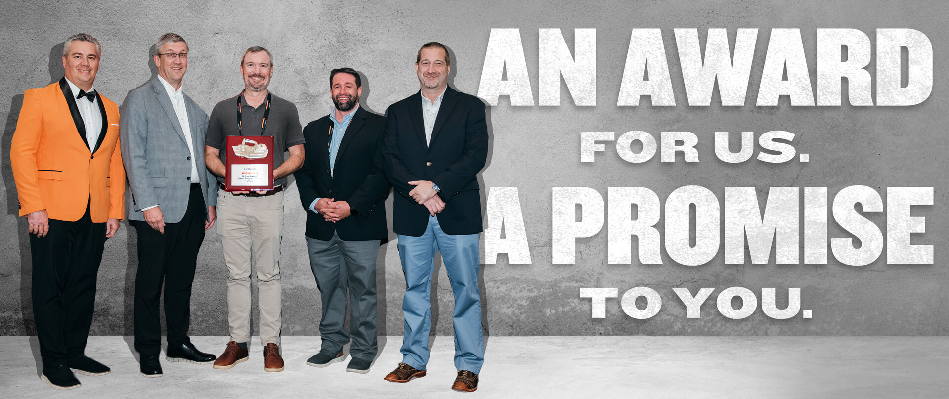 The staff of Steen Enterprises standing on a gray background with large bold type to the right that says "An award from us. A promise to you."