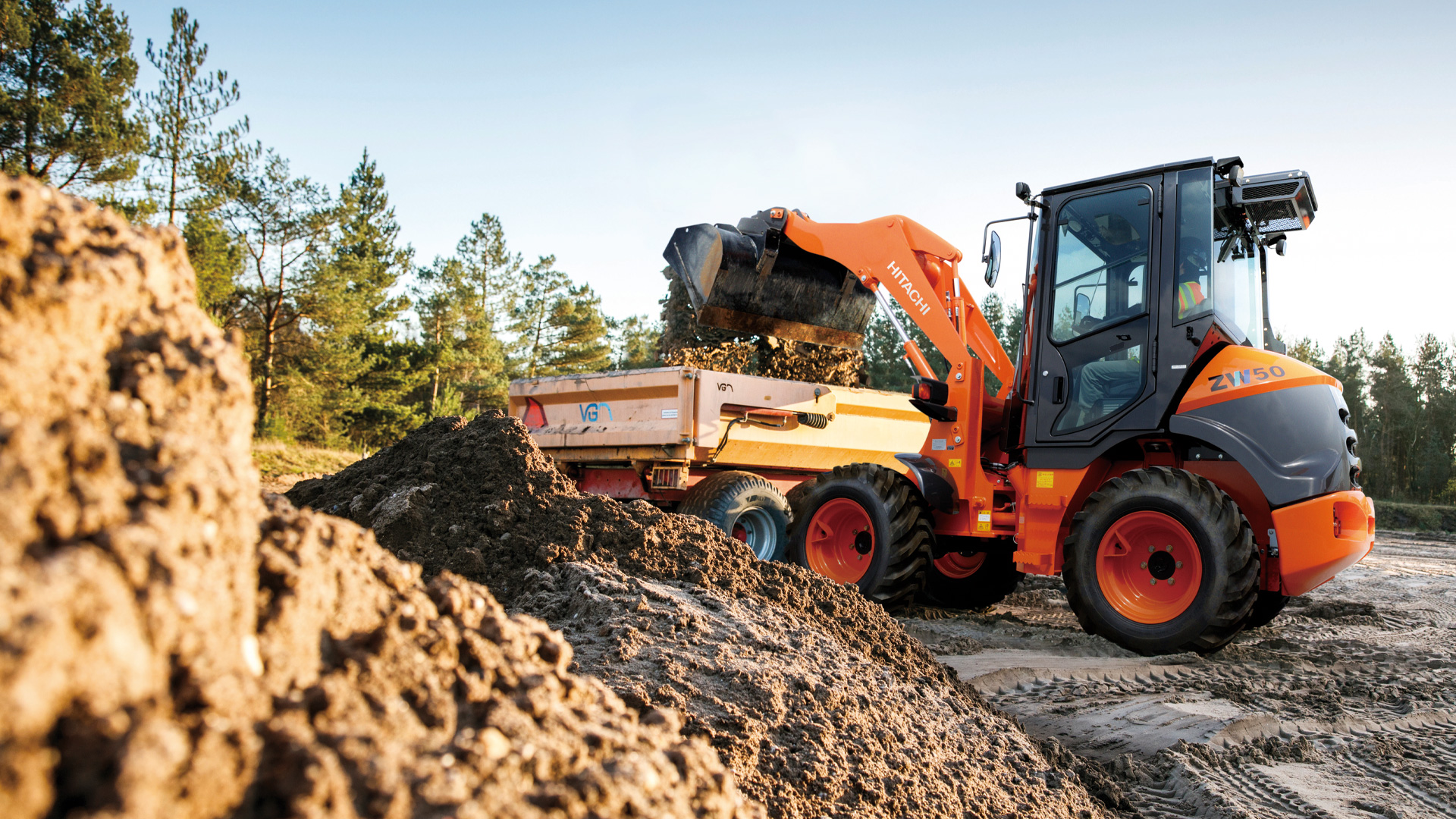 Hitachi ZW50 loading dirt and clearing land.