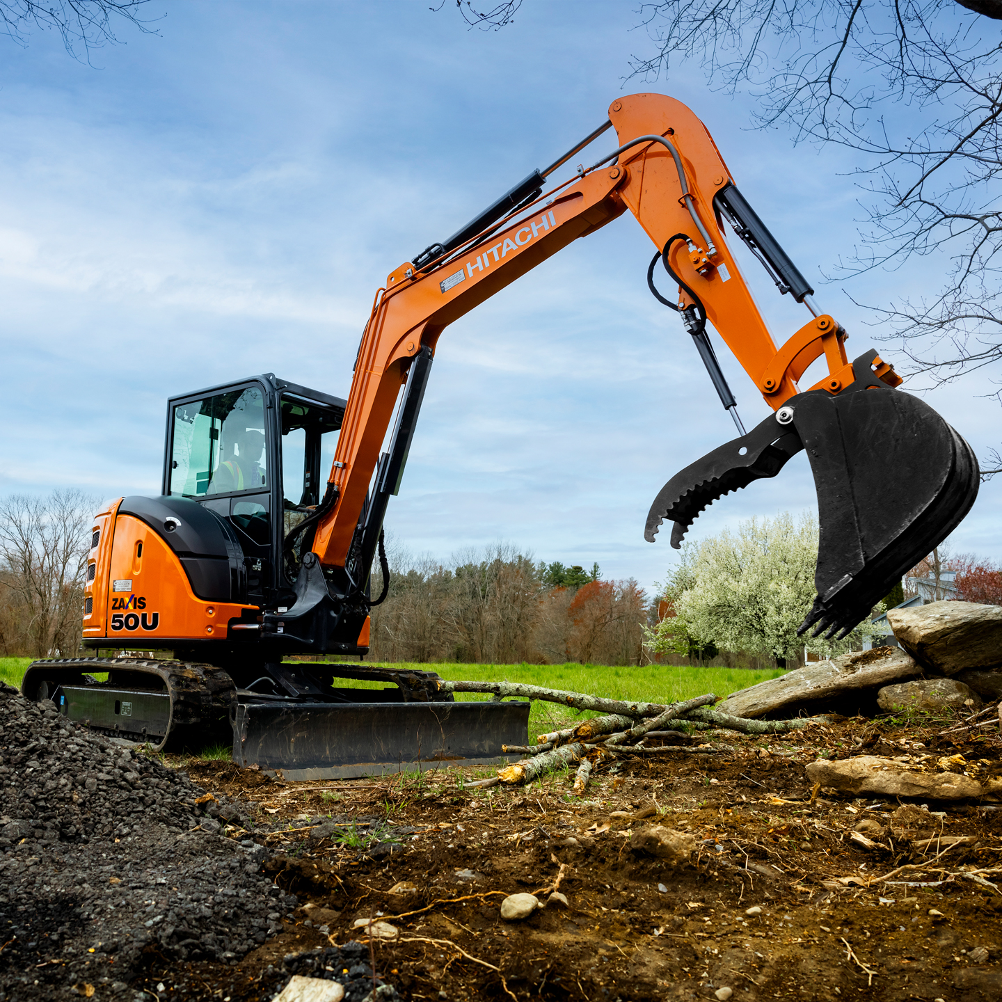 Person in a Hitachi ZX50 tractor on a jobsite.