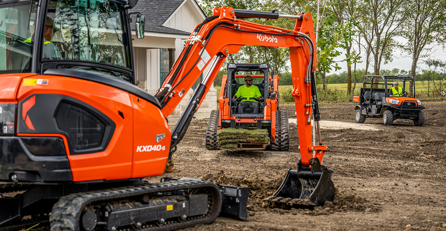 Construction crew with various pieces of Kubota equipment on a construction site.