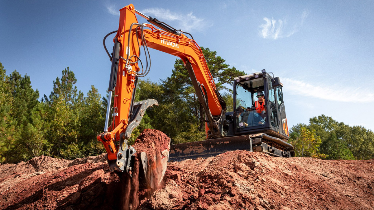 A Hitachi excavator on a construction site from a low angle.