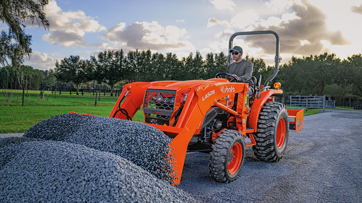 Kubota L2502 on a rural, gravel road at dusk.